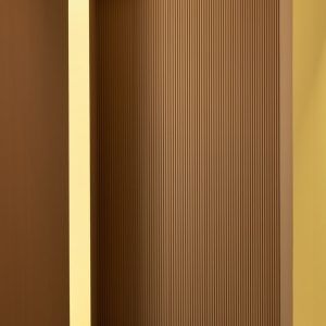 A close-up of a light brown 3D wall panel with vertical ridges, set against a yellow wall. The panel is framed by a slightly darker yellow border.